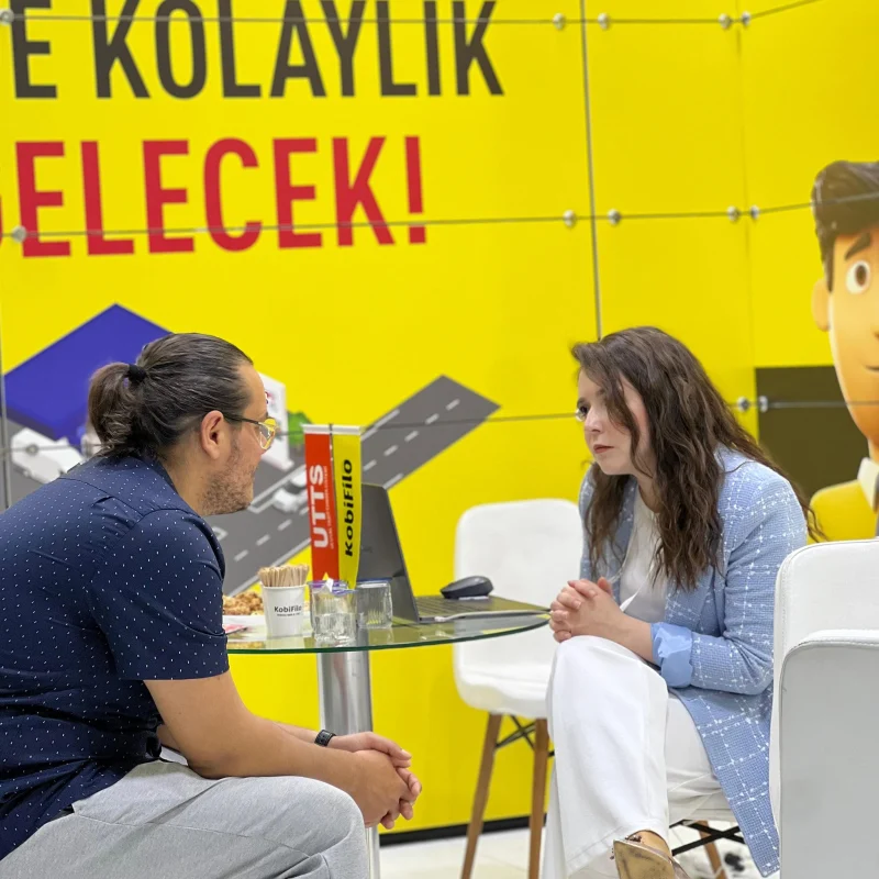 KobiFilo fuar standında masa başında hizmet görüşmesi